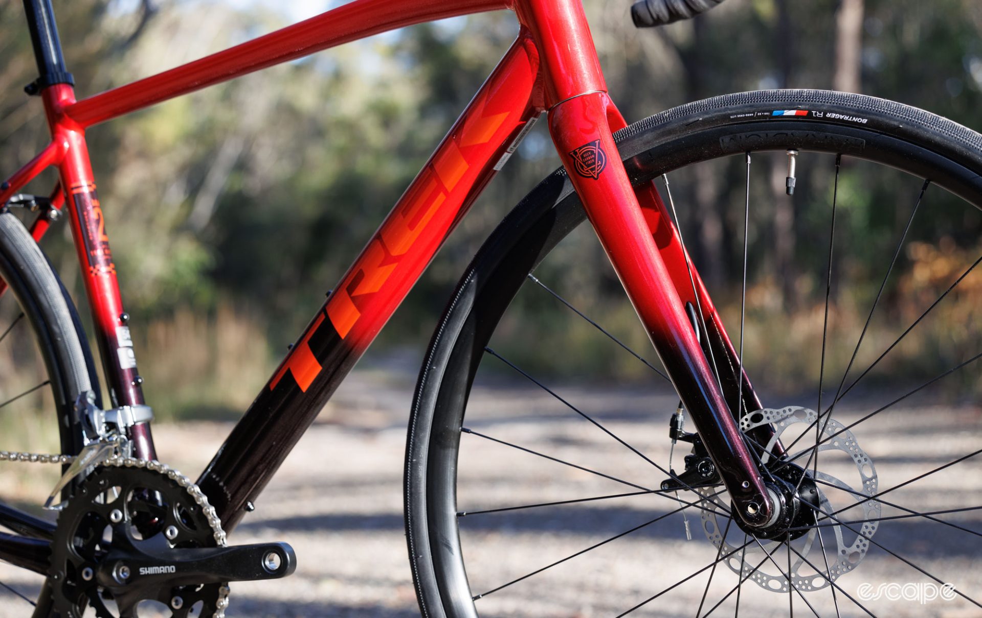 A wide photo showing the front end of the bicycle, with the fork in focus. It shows a red paint that fades to a deeper colour at the fork blade. 