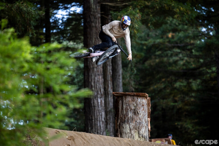 Emil Johansson catches air on a jump at Crankworx Rotorua in 2023. He is whipping the bike sideways as he sets up for the landing, roughly 10 feet below him.